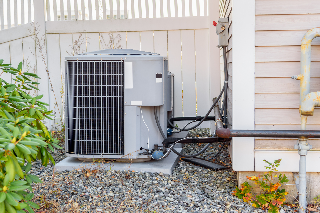 Outdoor air conditioning unit beside a house.